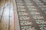 Textural distressed Konya rug with repeating cream and peach floral motifs.