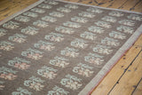 Distressed Konya rug edge, pale green and peach florals on charcoal field.