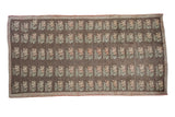 Distressed Konya carpet featuring repeating pastel floral motifs on a charcoal field, 5x9.5.