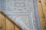 Distressed Oushak runner with hand-knotted foundation, soft worn pile, and pastel colors.