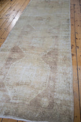 Blanched, distressed texture of a vintage Oushak runner with subtle motifs.