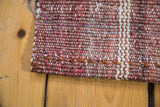 Kilim rug runner's flat weave, rose red and wine burgundy striations, stitched edge.