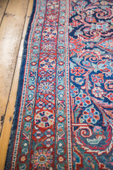 Meandering leaf border and curvilinear patterns on a vintage Mahal rug in brick red and indigo.