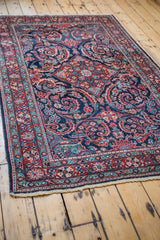 Vintage Mahal rug corner with intricate scrolling leaves and brick red meandering border.