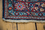 Vintage Mahal rug corner, indigo, brick red, and aqua meandering leaf border design.