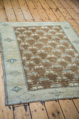 Vintage Turkish Oushak rug's brilliant bronze field with blanched floral motifs and geometric border.