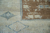 Bronze field with blanched silvery beige border and soft grey-blue patterns on vintage Oushak rug.