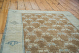 Vintage Turkish Oushak rug section with brilliant bronze field, blanched grey-blue floral motifs, and silvery beige geometric border.
