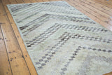 Worn texture and faded ivory, charcoal, rose, and moss green checker motif.