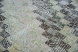 Modern distressed Oushak rug detail, faded checker pattern, soft texture, ivory, moss green, charcoal.