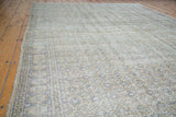 Distressed Oushak carpet pile reveals subtle medallion patterns in soft beige and greyish blue.