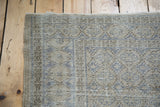 Distressed Oushak carpet pile showing subtle repeating patterns in muted beige and grey.