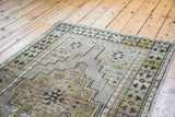 Distressed vintage Oushak runner corner with softened bronze, celadon, and mauve hues.