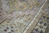 Distressed vintage Oushak runner with muted bronze, celadon, blue, and mauve geometric pattern.