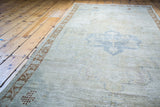 Distressed Oushak runner showing blanched texture and bronze meandering leaf border.