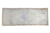 Distressed Oushak rug runner with blanched ivory field, faded blue medallion, bronze border. 4'3