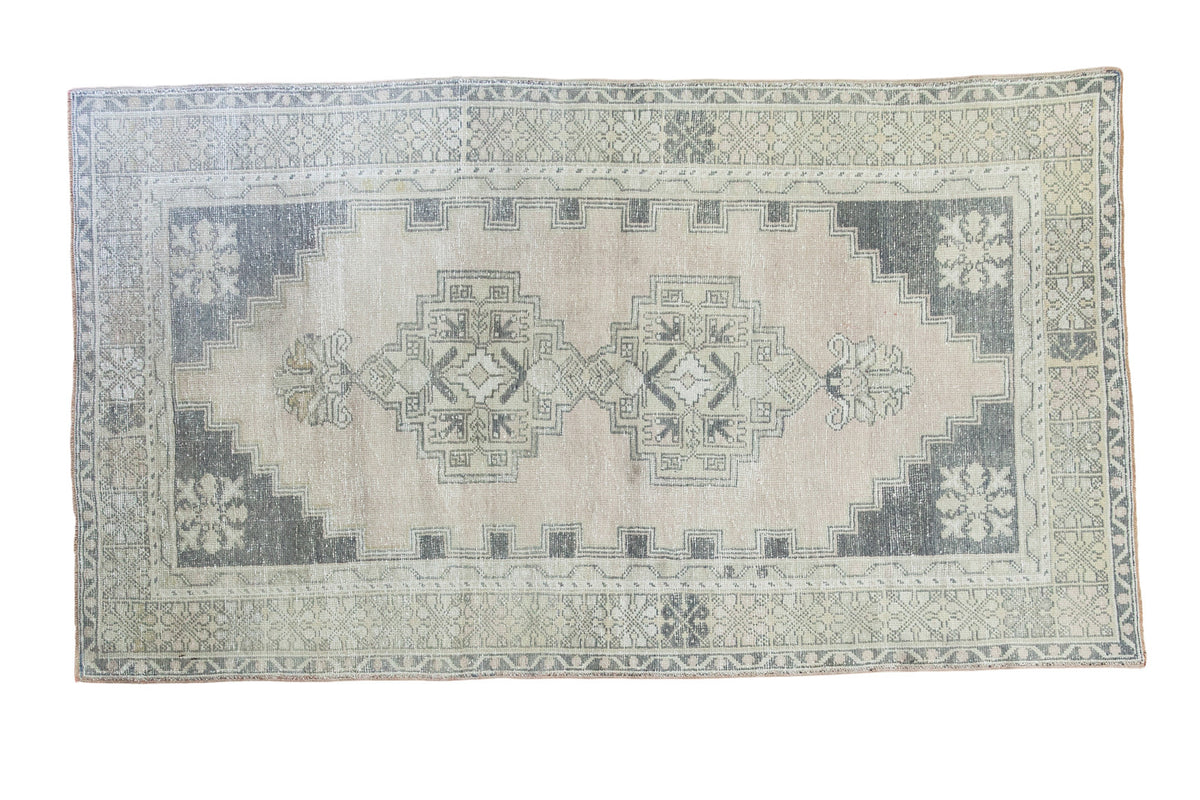Distressed blanched Oushak rug, rosy beige field, charcoal geometric medallion, 3'10" x 6'9".