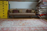 Distressed vintage Turkish Oushak rug with faded ivory-grey field and bold brick red medallion pattern.