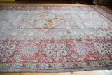 Distressed Oushak rug border with brick red geometric patterns and faded steel blue field.