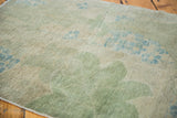 Distressed Oushak rug texture, muted green and blue arts and crafts plant motif.