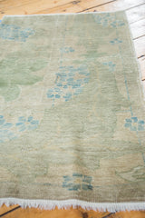 Distressed Oushak rug pile; sage green, blue arts and crafts plant motifs; white fringe.