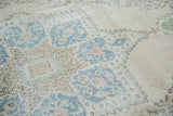 Decorative European distressed Oushak rug detail with blanched aqua floral palmettes.