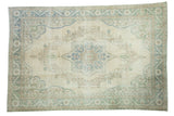 Distressed Oushak rug with large central medallion, blanched aqua palmettes, and blue-green border.