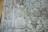 Softened distressed Oushak rug pile, showcasing faded ivory and earth tones.