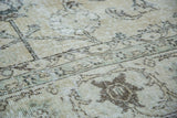 Distressed Oushak rug's softened pile with faded ivory and subtle earth tone patterns.