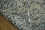 Distressed Oushak carpet corner revealing faded patterns and tightly woven foundation.