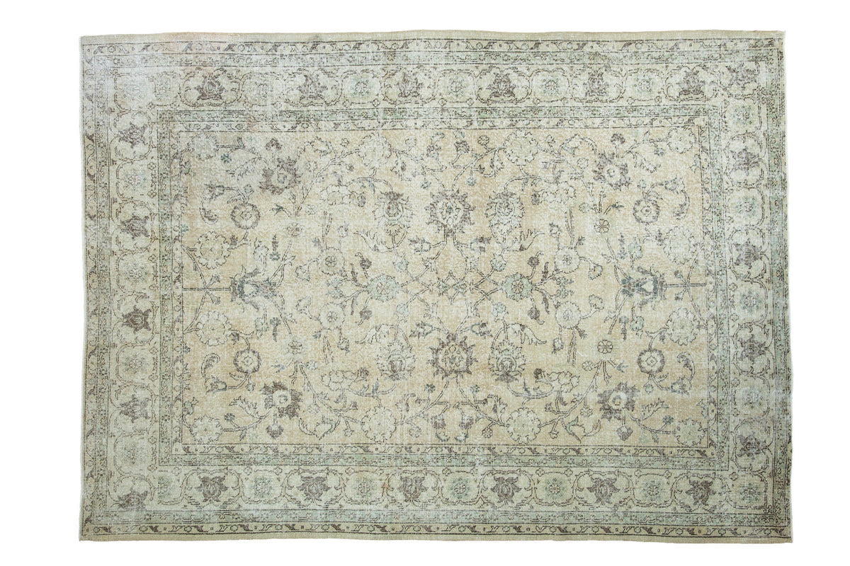 Vintage Turkish Oushak rug with distressed allover floral design, softened ivory and earth tones, 7x9.5 feet.