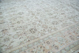 Distressed Oushak carpet, softened ivory, earth tone floral patterns, and muted border.