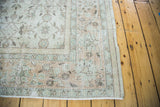 Distressed vintage Oushak rug corner with faded ivory and soft earth tones.