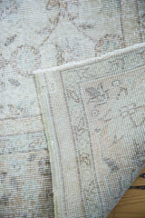 Softened distressed Oushak carpet pile and tightly woven foundation, featuring faded ivory and earth tones.