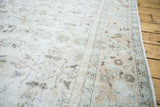 Distressed Oushak rug pile texture showing faded ivory and earthy soft green tones.