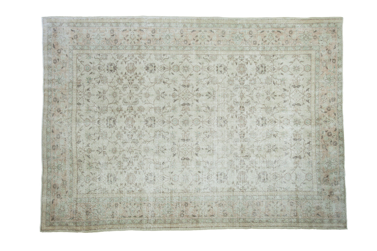 Distressed Oushak carpet featuring faded floral designs, softened ivory and earth tones, 7'1" x 10'.