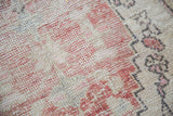 Distressed Oushak rug, circa 1940s, with muted red, cream patterns and worn low pile.