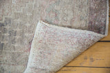 Distressed Oushak runner pile with muted color and visible hand-knotted foundation.