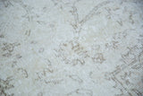 Distressed vintage Oushak carpet pile featuring blanched ivory and subtle silvery patterns.
