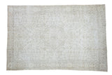 Distressed vintage Turkish Oushak rug, blanched ivory field with subtle charcoal medallion.