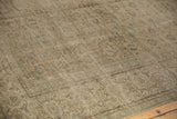 Distressed Oushak carpet showing intricate repeating pattern in blanched ivory, green, beige.