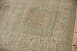 Distressed texture and intricate blanched ivory, green, beige pattern on a vintage Oushak rug.