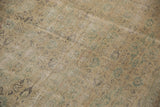 Decorative distressed Oushak rug texture featuring blanched ivory, green, and beige tones.
