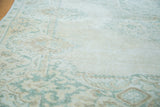 Blanched ivory and green patterns with distressed texture on this vintage Oushak rug.