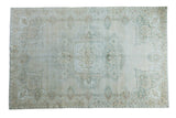 Distressed Oushak carpet featuring a blanched ivory and green medallion, 6' x 9'5