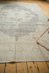 Distressed pile texture with blanched ivory, beige, and charcoal tones on a vintage Oushak carpet.