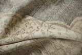 Decorative folded texture of a distressed Oushak carpet in blanched ivory and charcoal.