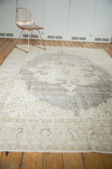 Distressed Oushak carpet with blanched ivory, beige, charcoal scalloped medallion.