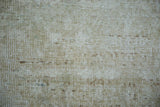 Distressed Oushak carpet pile with muted beige and cream tones.