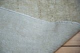 Hand-knotted foundation and distressed pile texture of a vintage Oushak carpet.